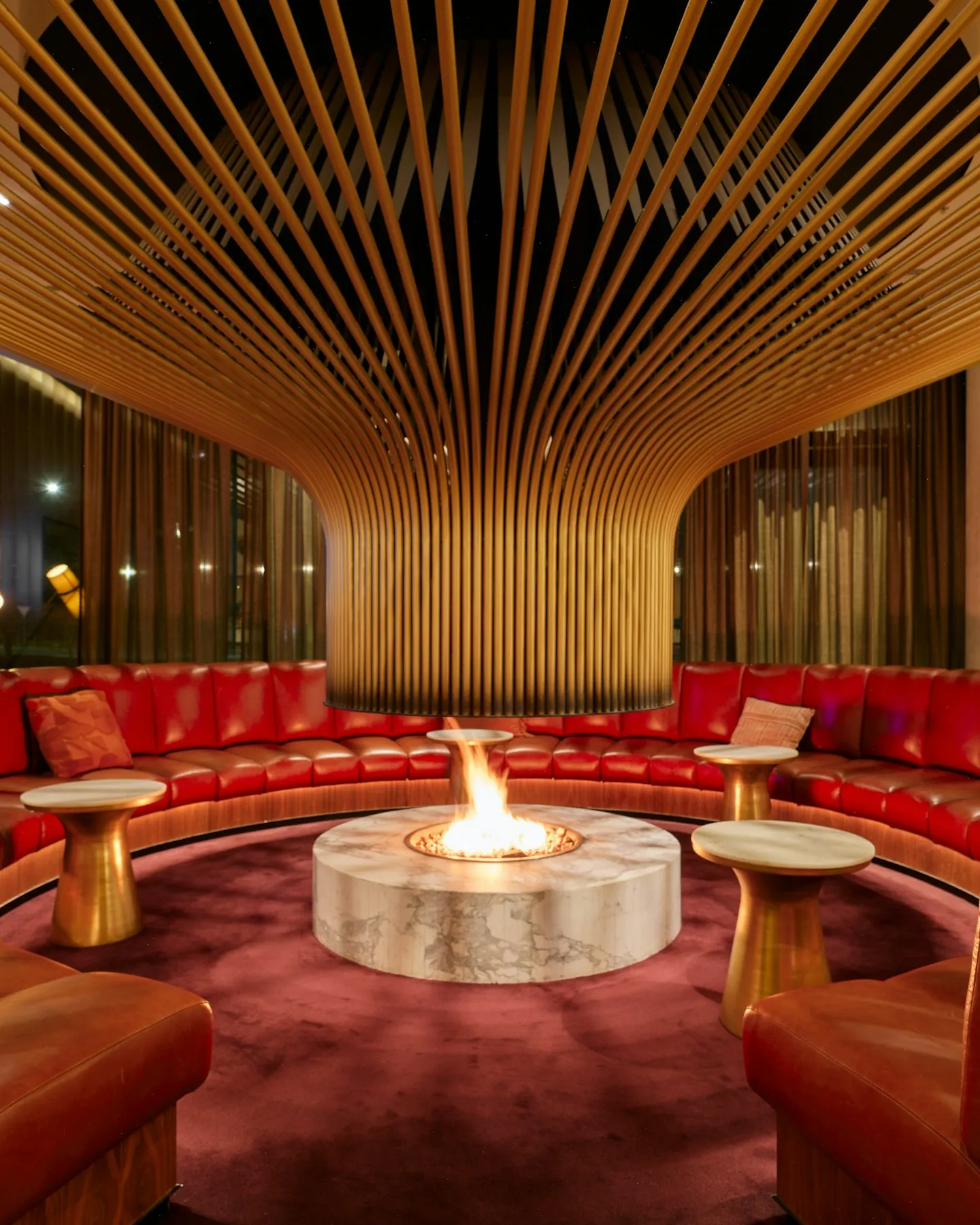 A private lounge with leather banquettes around an open fire